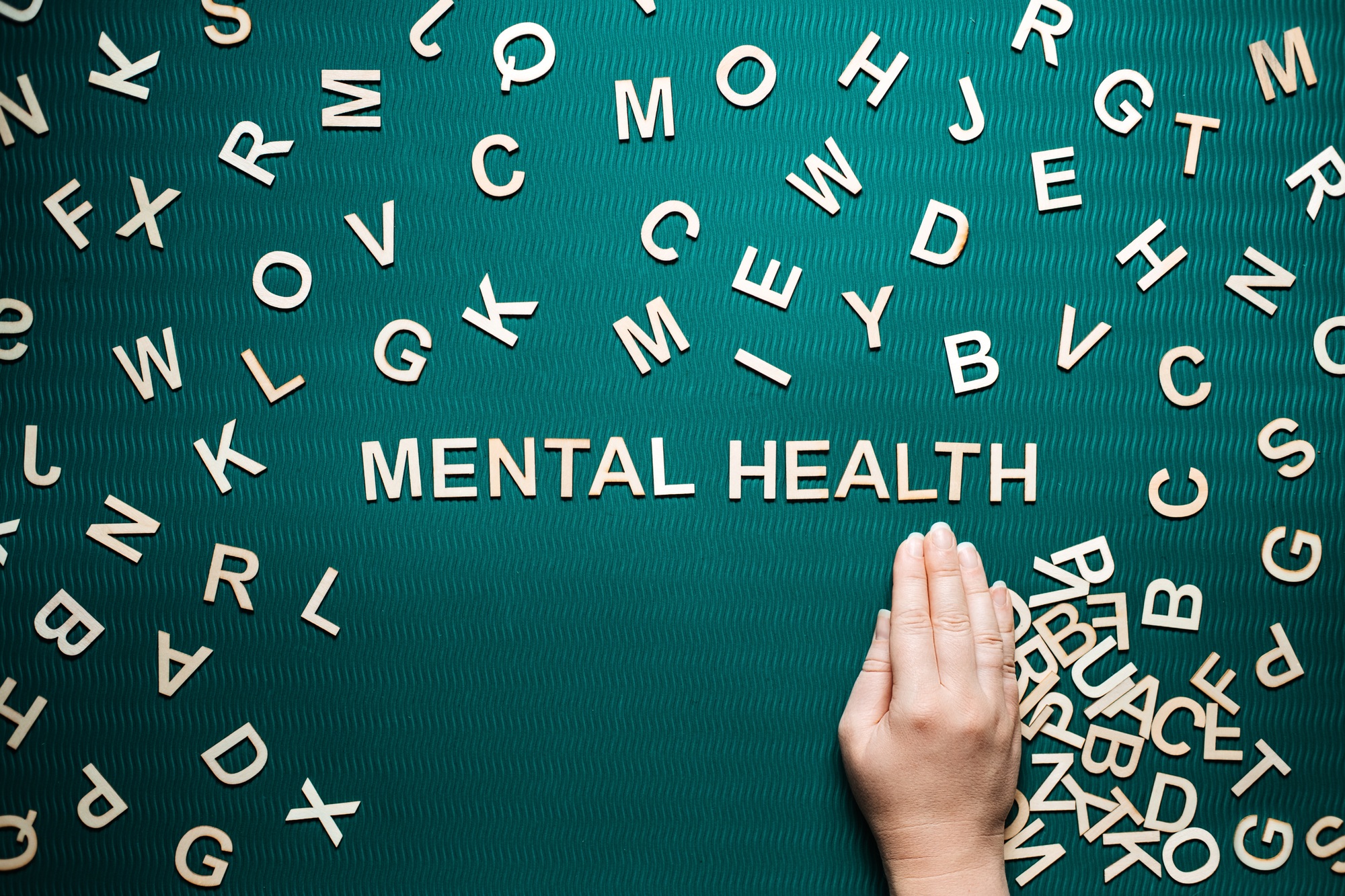 Mental health word from wooden letters. Mental health text on green background with many other